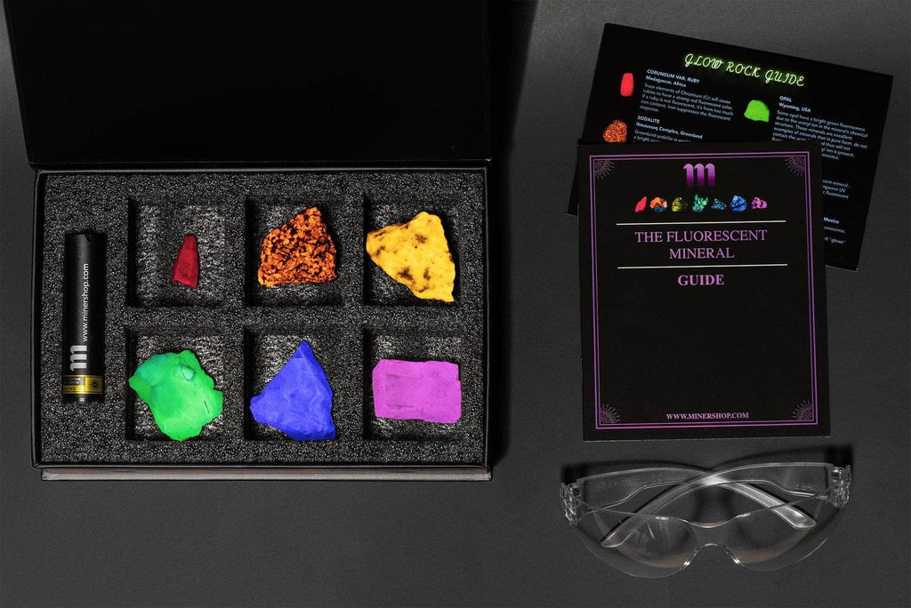 fluorescent mineral collection box showing fluorescent sodalite, green opal, purple fluorite, calcite rhomb, fluorescent ruby