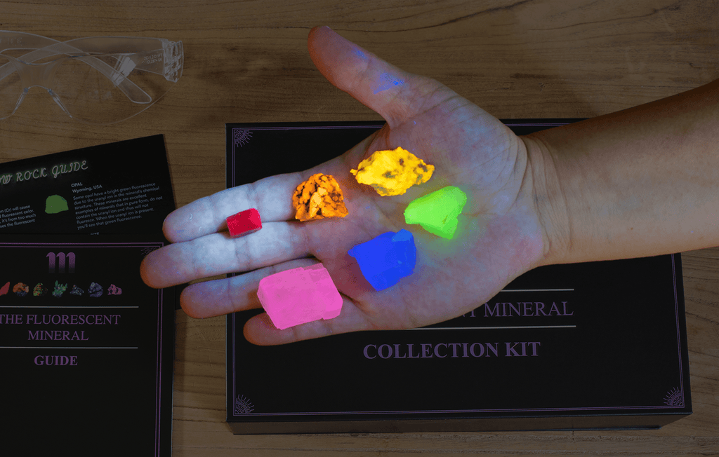 fluorescent mineral kit containing a UV flashlight, ruby, fluorescent sodalite, wernerite, opal, fluorite, calcite rhomb