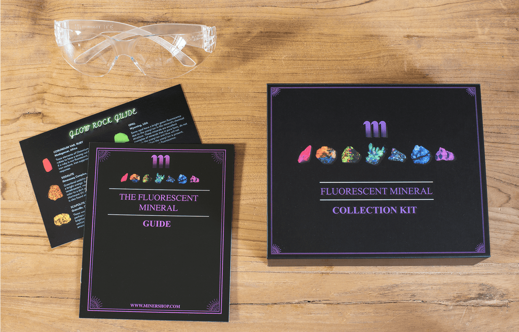 fluorescent mineral kit containing a UV flashlight, ruby, fluorescent sodalite, wernerite, opal, fluorite, calcite rhomb