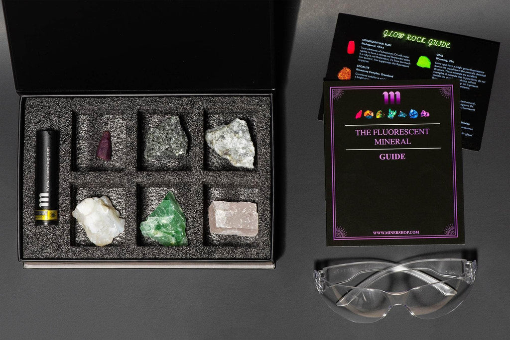 fluorescent mineral collection box showing fluorescent sodalite, green opal, purple fluorite, calcite rhomb, fluorescent ruby