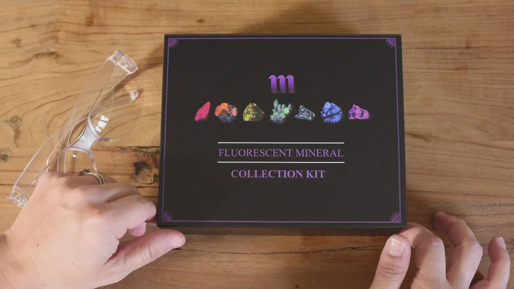 fluorescent mineral kit containing a UV flashlight, ruby, fluorescent sodalite, wernerite, opal, fluorite, calcite rhomb